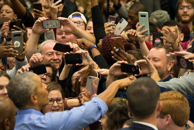 Attendees attempt to take photos of former President Barack Obama after he spoke at a rally in Milwaukee during the midterm elections in 2018. He returns to the city on Saturday as Democrats seek to ramp up voter enthusiasm ahead of the Nov. 8 election.