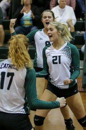 Pensacola Catholic's Terra Warrington (8), Hannah Meyers (17), and Molley Majewski (21) celebrate after Majewski scored a point against Marianna in the Region 1-5A quarterfinal game at Catholic High School on Thursday, October 25, 2018. The Crusaders defeated the Bulldogs in three straight sets and will face Florida High next week in the region semifinal game.