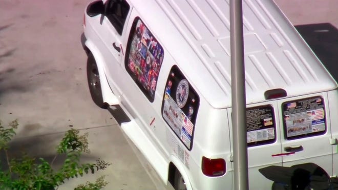 This frame grab from video provided by WPLG-TV shows a van parked in Plantation, Fla., on Friday, Oct. 26, 2018, that federal agents and police officers have been examining in connection with package bombs that were sent to high-profile critics of President Donald Trump. The van has several stickers on the windows, including American flags, decals with logos and text. (WPLG-TV via AP)