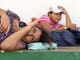 Angelica Esmeralda Sanchez,18, left, and her friend Ericka Martinez 28, both from El Salvador are with a new wave of several hundred migrants gathered near a park in Tecum Uman, Guatemala on Oct. 25, 2018. They are waiting to cross into Mexico and to head north to the United States.