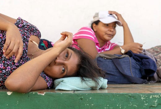 Angelica Esmeralda Sanchez,18, left, and her friend Ericka Martinez 28, both from El Salvador are with a new wave of several hundred migrants gathered near a park in Tecum Uman, Guatemala on Oct. 25, 2018. They are waiting to cross into Mexico and to head north to the United States.