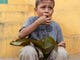 Gerson de Jesus Zelaya, 6, from Honduras, eats a donated lunch near a park in Tecum Uman, Guatemala as he waits to cross from Guatemala to Mexico and to head north to the United States on Oct 25, 2018. 