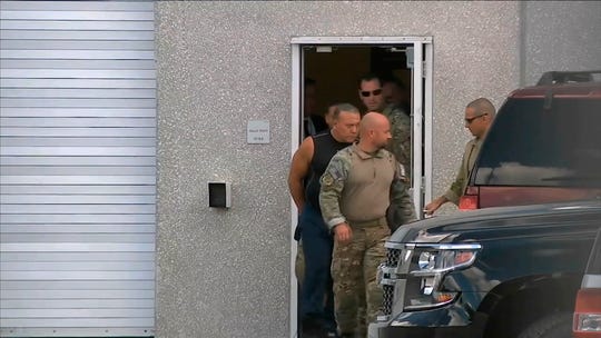 This screenshot taken from a video provided by WPLG-TV shows FBI agents escorting Cesar Sayoc in a sleeveless shirt in Miramar, Florida on Friday, October 26, 2018. Sayoc is an amateur bodybuilder and a former stripper, a long history of arrest who showed little interest in politics until Donald Trump arrived. On Friday, he was identified by authorities as the Florida man who had placed pipe bombs in small manila envelopes, affixed six stamps and sent them to some of Donald Trump's most prominent critics.