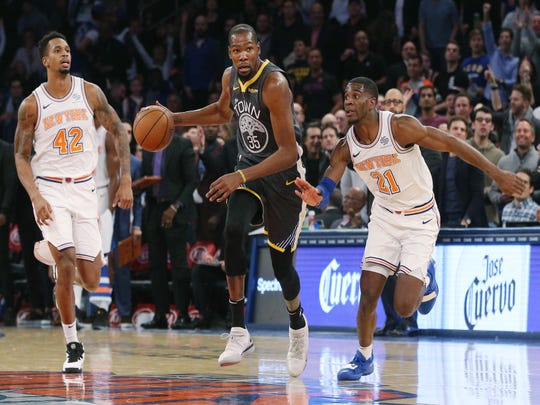 October 26, 2018; New York, NY, USA; Forward Kevin Durant (35) of the Golden State Warriors controls the ball against striker Lance Thomas (42) of the New York Knicks and guard Damyean Dotson (21) of the New York Knicks at Madison Square Garden.