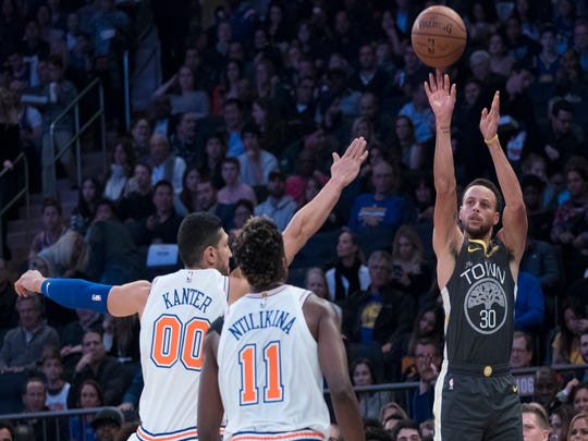 Silver State Warriors goaltender Stephen Curry (30) shoots a three-point basket over goaltender Frank Ntilikina (11) of the New York Knicks and center Enes Kanter (00) in the first half of the year. an NBA basketball game on Friday, October 26, 2018 at Madison Square Garden in New York.