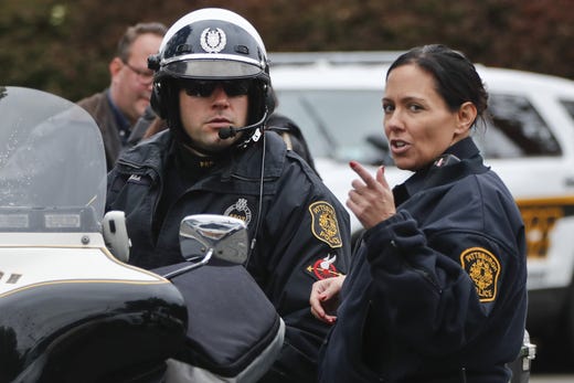 Pittsburgh police talk in the streets of the Squirrel Hill neighborhood of Pittsburgh where a shooter opened fire during services at the Tree of Life Synagogue on Saturday, Oct. 27, 2018. (AP Photo/Keith Srakocic)