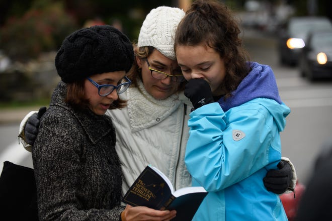 Tammy Hepps, left, Kate Rothstein and her daughter, Simone Rothstein, 16, pray a block away from the site of a mass shooting at the Tree of Life Synagogue in Pittsburgh.