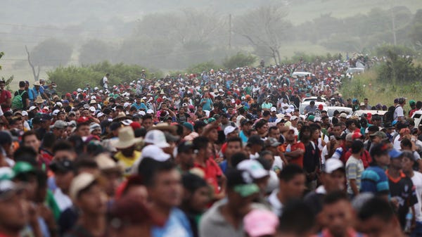 Members of a U.S.-bound migrant caravan stand on...