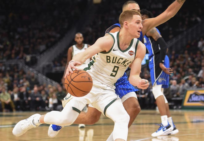 Bucks guard Donte DiVincenzo drives to the basket against Magic guard Evan Fournier. DiVincenzo hasn't played an NBA game since Jan. 1.