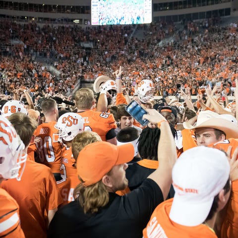 Oklahoma State fans rush the field after the...