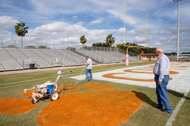 Billy Riojas grounds keeper at Alice High School's Coyote Stadium supervisors as the end zone is painted on Tuesday, Oct. 30, 2-018 