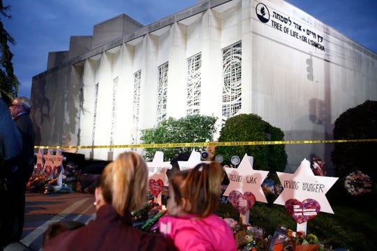 A family looks on at the Star of David memorials at the Tree of Life Synagogue days after a mass shooting in Pittsburgh, Pennsylvania.