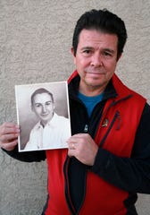 This Tuesday, Oct. 30, 2018, photo provided by Reuben Ortiz, shows Ortiz holding a photo of the Rev. Jerome Coyle in Albuquerque, N.M. Ortiz says he was angered to learn that Coyle, who had been living at his home until recently, admitted in 1986 that he sexually abused 50 Iowa boys and that the church has kept it quiet for decades.