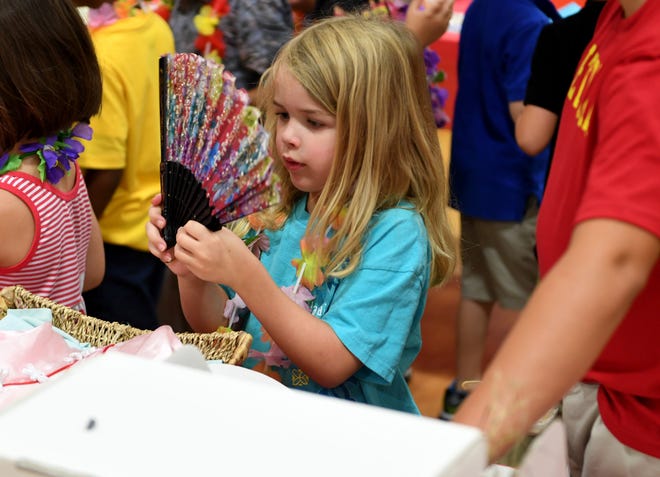 Delaney Blackwood examines a fan at the Multi-cultural Market at Community Montessori, Wednesday, October 31.