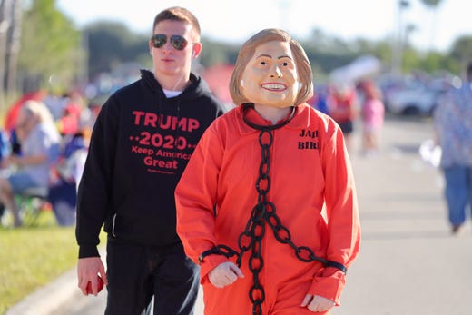 Eli Torres of Lehigh Acres, dressed as Hillary Clinton, walks with her son Caleb Torres on Wednesday, Oct. 31, 2018 as supporters of President Trump line up for his rally at Hertz Arena.