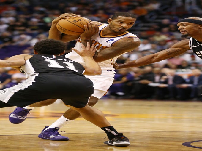 Phoenix Suns forward Trevor Ariza dives to the basket against the San Antonio Spurs' Bryn Forbes in the first half on Oct. 31 at Talking Stick Resort Arena.