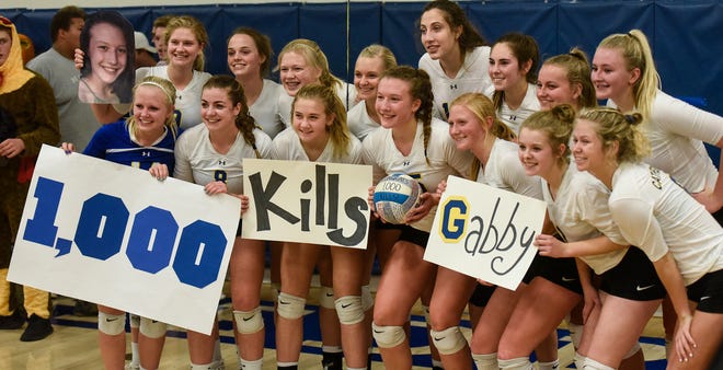 Team members gather to celebrate Gabby Heying's 1,000th kill following  the Tuesday, Oct. 30, Section 6-2A volleyball quarterfinals game against Melrose at Cathedral High School in St. Cloud. 