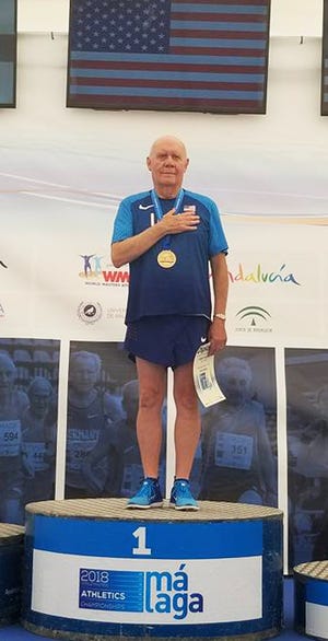 Bob Arledge stands at attention wearing his gold medal with American flag displayed above him and the national anthem playing after winning in Malaga, Spain, Sept. 12