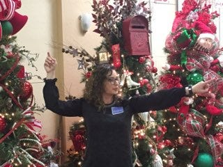 Jennifer Lemons points to a bidder during the Assistance League of Carlsbad's Christmas Tree Auction Thursday night.