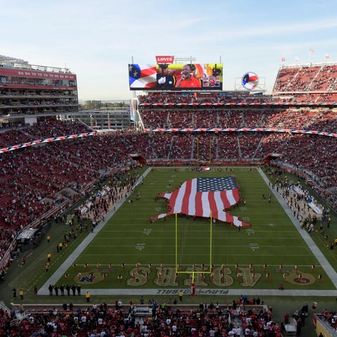 An American flag covers half the field during the...