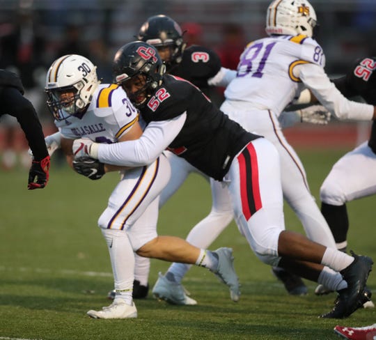 Warren De La Salle's Brett Stanley is tackled by Oak Park's Justin Rogers on Friday, November 2, 2018 at Oak Park High School in Oak Park, Mich.