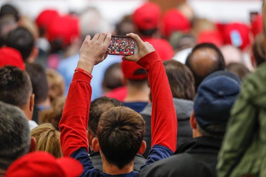 A young man takes video on his phone as United States President Donald Trump campaigns for Republican candidate Mike Braun during a rally at Southport Fieldhouse on Friday, Nov. 2, 2018.