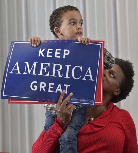 Reidyr Morris, 2, and his mother Shavon Morris get read on Saturday, Nov. 3, 2018, for President Donald Trump's rally at the Pensacola International Airport.