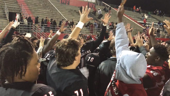 West Florida football players hold up the number five to celebrate a fifth consecutive district title after defeating Washington 35-14 on Nov. 2.