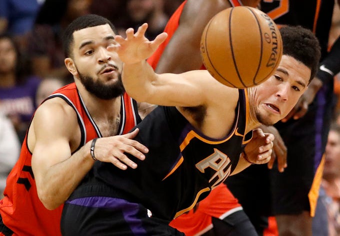 Phoenix Suns guard Devin Booker, right, and Toronto Raptors guard Fred VanVleet battle for the ball during the first half of an NBA basketball game, Friday, Nov. 2, 2018, in Phoenix.
