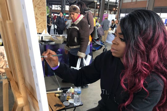 Artist Christina Madison, of Detroit, sells her paintings and creates a piece live at the All Things Detroit shopping experience at Eastern Market on Sunday, Nov. 4, 2018.