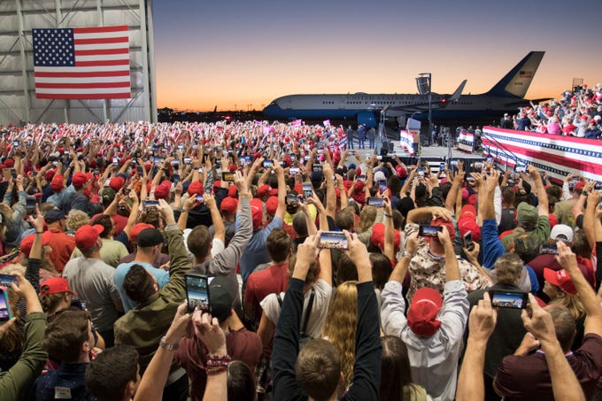 Thousands of supporters hold up their cellphones to snap a photo of Air Force One arriving Saturday, Nov. 3, 2018, at the ST Engineering hangar at the Pensacola International Airport for President Donald Trump's rally.