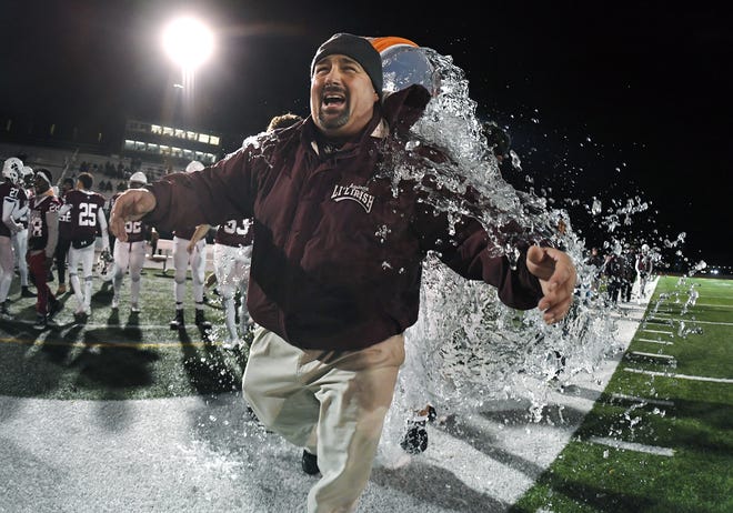 Aquinas head coach Derek Annechino is doused with water in the closing seconds of the Section V Class AA championship game at SUNY Brockport, Saturday, Nov.  3, 2018. Aquinas won the Class AA title with a 49-18 win over McQuaid.