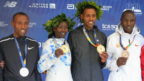 Men's winner Lelisa Desisa of Ethiopia (center)...