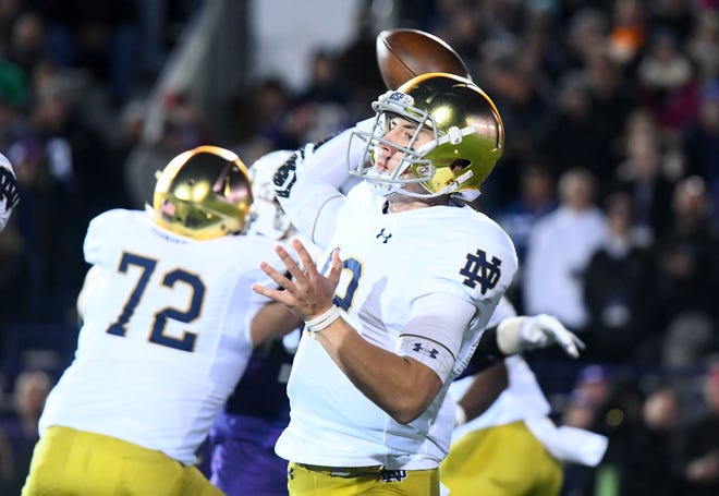 Notre Dame Fighting Irish quarterback Ian Book (12) drops back top pass against the Northwestern Wildcats during the first quarter at Ryan Field.