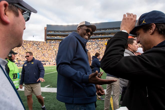 Former Michigan basketball player Chris Webber, center, goofs around on the sidelines during the first half Saturday in Ann Arbor.