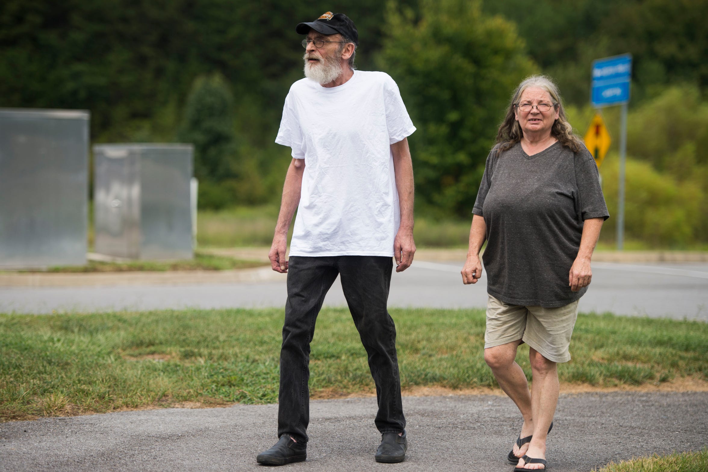 Alan Chrisman walks with his wife, Joyce, near the Sevierville, Tenn., McDonald's where he worked as a maintenance employee before being diagnosed with stage 4 colorectal cancer. Chrisman applied for disability but was initially denied based on a recommendation by a medical contractor hired by the state to review claims.