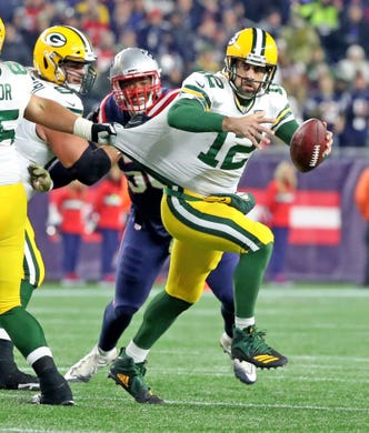 Green Bay Packers quarterback Aaron Rodgers (12) is grabbed by his jersey on a scramble against the New England Patriots Sunday, November 4, 2018 at Gillette Stadium in Foxborough, Mass.
