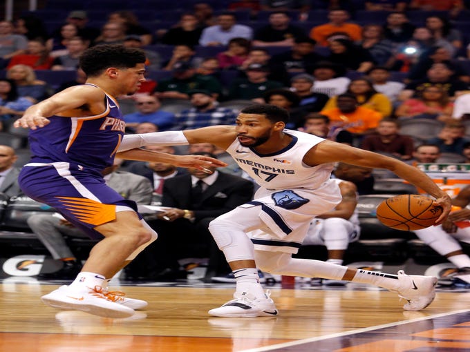 Memphis Grizzlies guard Garrett Temple (17) shields the ball from Phoenix Suns guard Devin Booker in the first half during an NBA basketball game, Sunday, Nov. 4, 2018, in Phoenix.