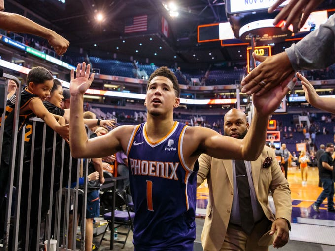 Nov 4, 2018; Phoenix, AZ, USA; Phoenix Suns guard Devin Booker (1) celebrates with fans following the game against the Memphis Grizzlies at Talking Stick Resort Arena.