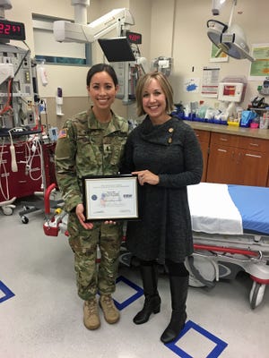 Megan King, left, presents a Patriot Award to Nancy Bee, nurse manager for the emergency department at Salem Hospital.