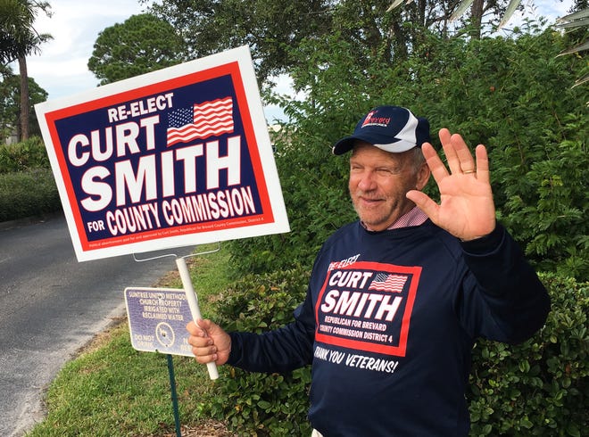 District 4 Brevard County Commissioner Curt Smith waving to drivers in passing vehicles from the entrance of Suntree United Methodist Church off of North Wickham Road.