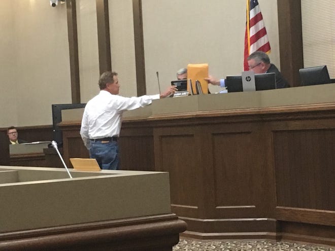 Keith Boyd hands off to County Mayor Jim Durrett, the petition opposing rezoning for apartments near his pumpkin patch.