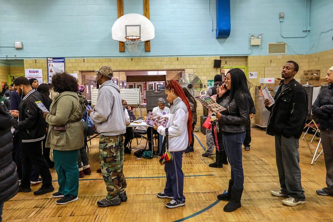 Voters stand in line waiting to cast their ballot at Bow Elementary School  where multiple precincts are located for the midterm elections in Detroit on Tuesday, Nov. 6, 2018.