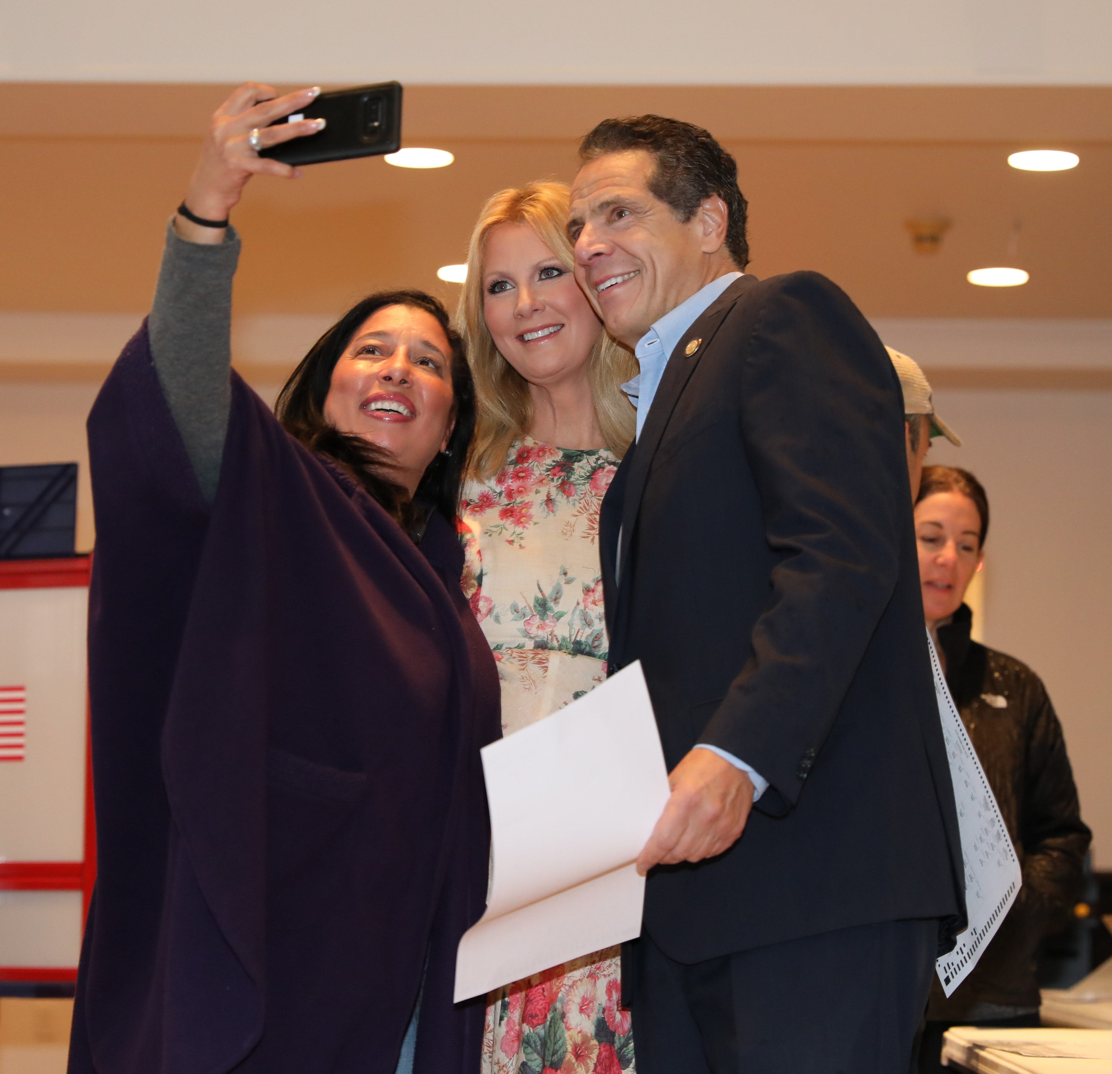 New York Governor Andrew Cuomo and girlfriend Sandra Lee take a selfie with a voter as they prepare to vote at the Presbyterian Church of Mount Kisco, Nov. 6, 2018. 