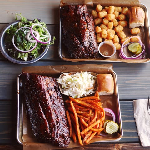 Two orders of ribs with sweet potato fries, tater...