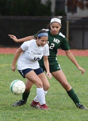Alyssa Genao (no. 12) of Midland Park (in green) pressures as Ashley Georgevich (no. 10) of Saddle Brook (in white) tries to control the ball during the North 1, Group 1 girls soccer semifinal at Midland Park High School on 11/07/18. Midland Park won the game 6 to 1. 