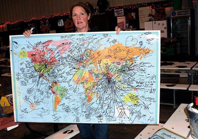 Tina Hinchley holds a map showing the homes of this years international visitors to the farm.