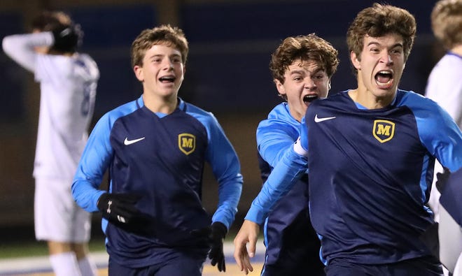 Moeller senior forward Jordan Walter reacts, with Parker Grinstead and Sam Hegge behind him, after scoring the winning goal in the 1-0 overtime win over Olentangy Liberty in their state semifinal game Wednesday, Nov. 7, 2018.