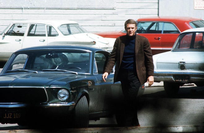 Steve McQueen, starring in the title role of "Bullitt," steps out of his car after a  pursuit through the hilly streets of San Francisco. The Technicolor action drama was filmed entirely on location in the Bay City.