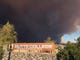 Smoke from the Camp Fire, burning in the Feather River Canyon near Paradise, Calif., darkens the sky above the Butte College sig in Oroville, Calif., Thursday, Nov. 8, 2018.